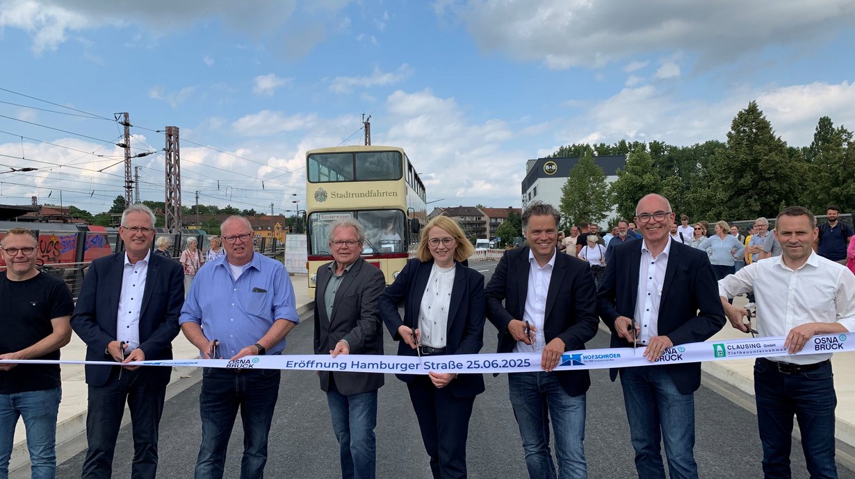 Mehrere Personen durchschneiden ein Band
